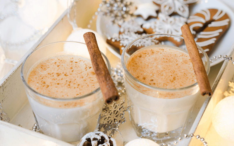 Glasses of gingerbread eggnog in a decorated box with gingerbread