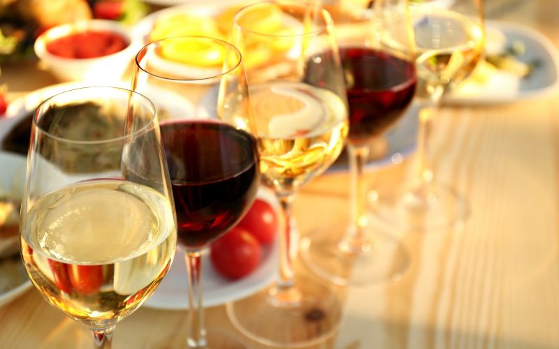 Glasses of Different Wines on Wooden Table