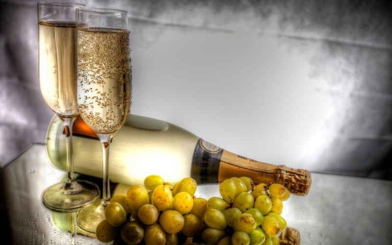 Glasses of Champagne with a bottle and grapes