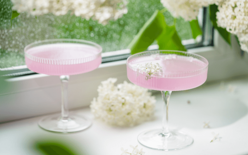 Glasses of garden party cocktail on a white surface