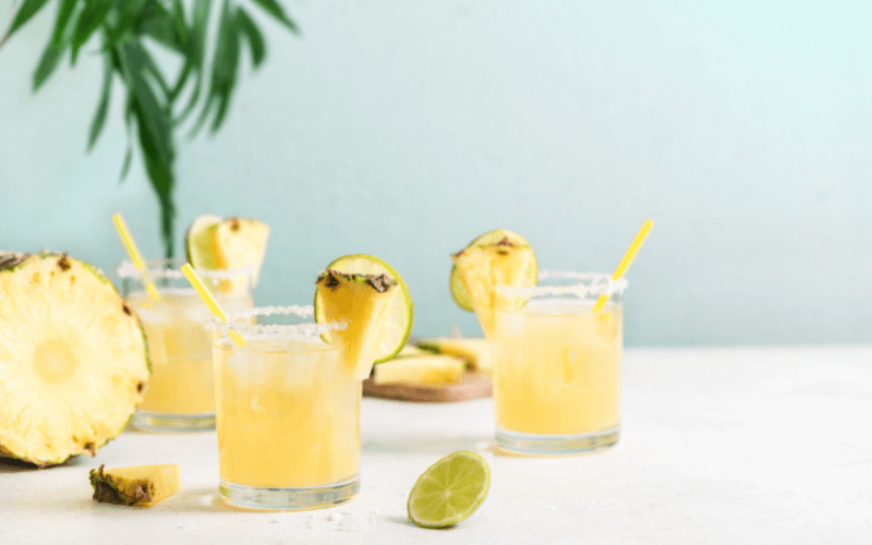 Glasses of pineapple cinnamon margarita in a light background