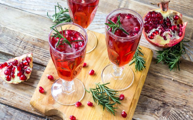 Glasses of pomegranate royal cocktails on a wooden surface