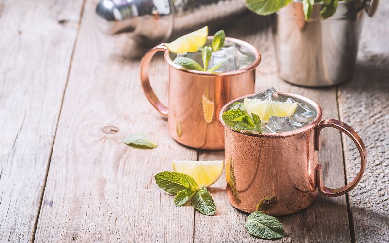 Glasses of whiskey ginger mule on a wooden surface