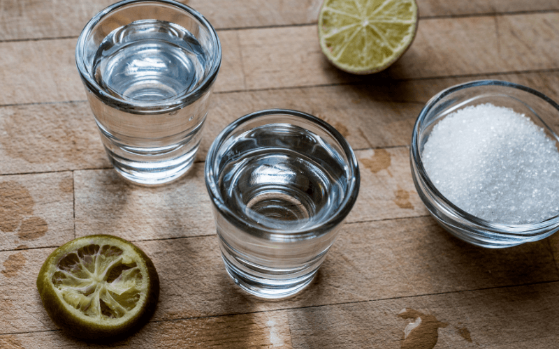 mezcal shot beside lime wheel and salt