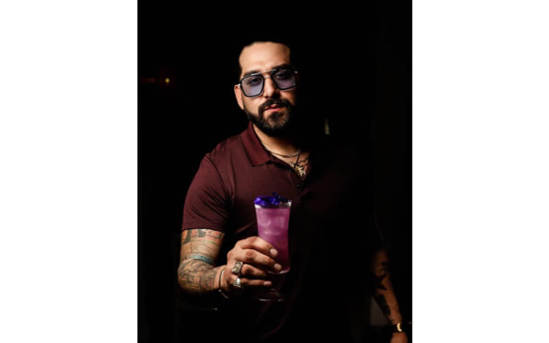 Lou Narvaez-Ochoa holding a glass of cocktail