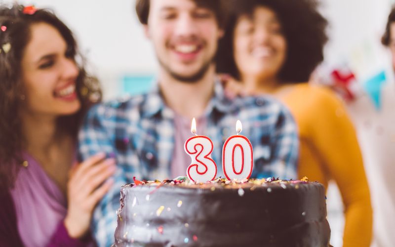 Man and friends with a 30th birthday cake