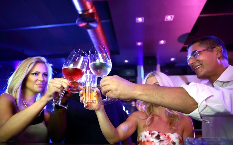 Man and women clinking glasses at a bar