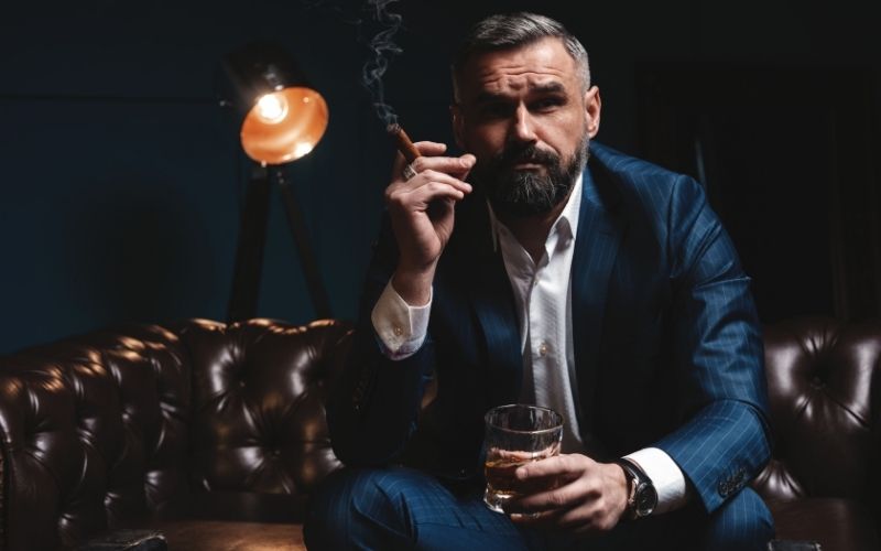 Man drinking brandy and smoking a cigar