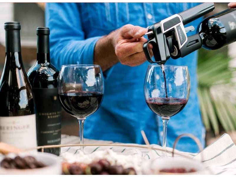 Man pouring bottle of wine using Coravin Model 2