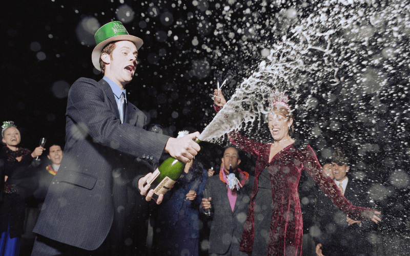 Man spraying Champagne at New Years Eve party