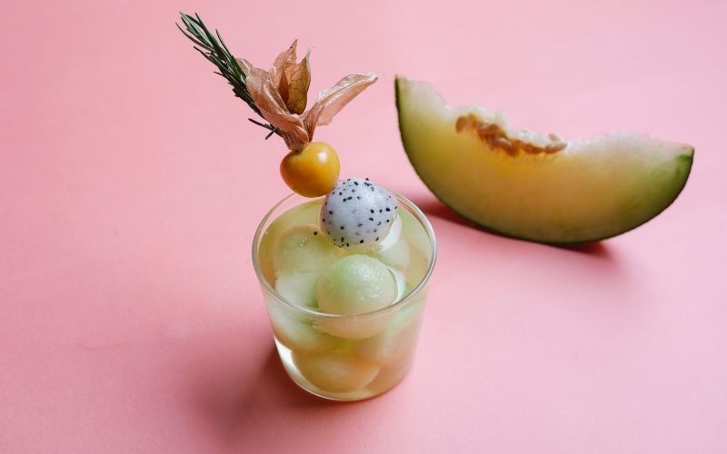 Melon cocktail garnished with dragon fruit balls and melon balls
