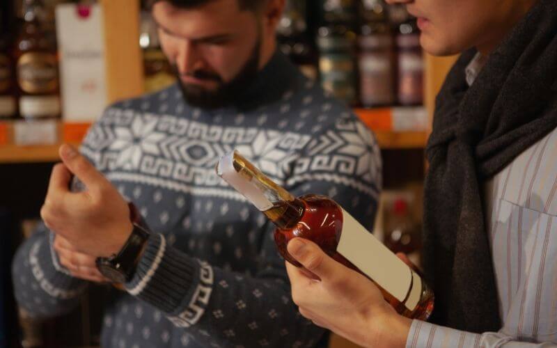 Men inspecting a liquor bottle