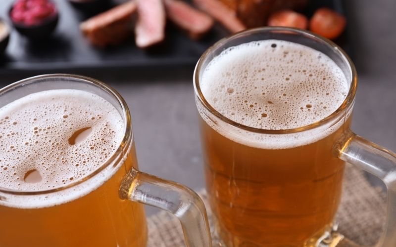 Mugs with Fresh Tasty Beer on Table