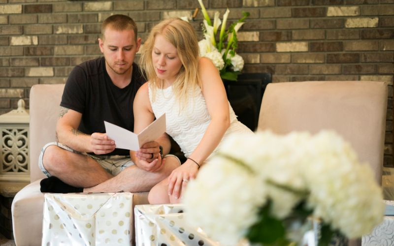 Newlywed couple reading gift greetings