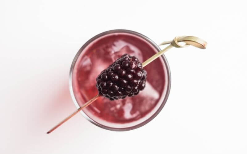 A serving of Nuanced New York Sour with skewered blackberry