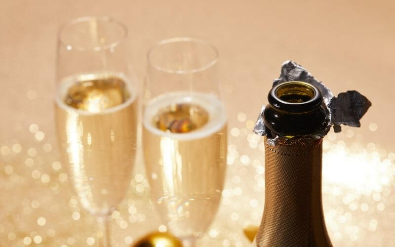 Opened Champagne bottle beside two glasses