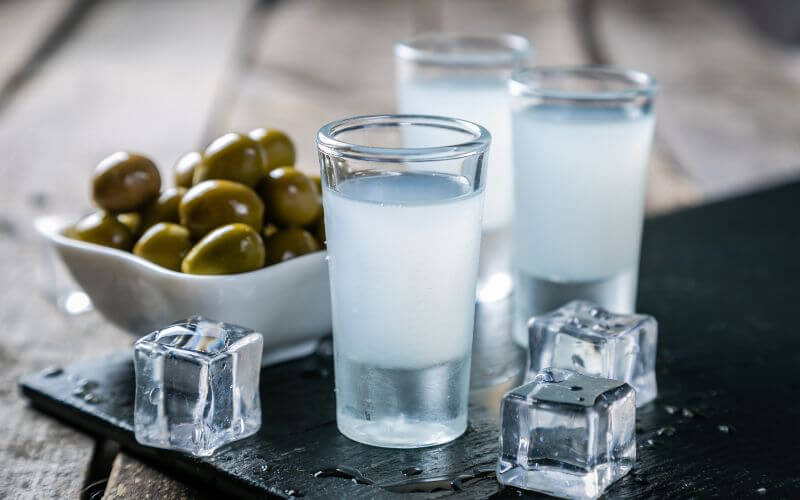 Ouzo in shot glasses and ice cubes 