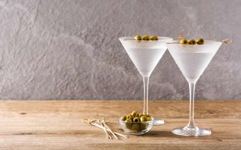 2 glasses of vodka topped with skewered olives