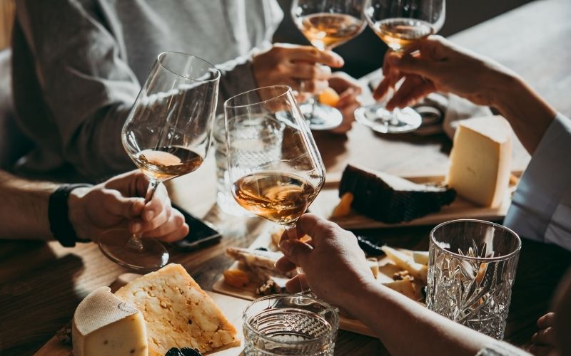 People toasting white wine glasses