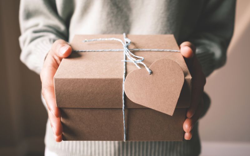 Person Holding a Brown Gift Box with a Heart Card