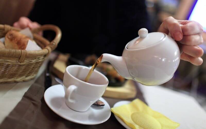 Person pouring tea on to teacup