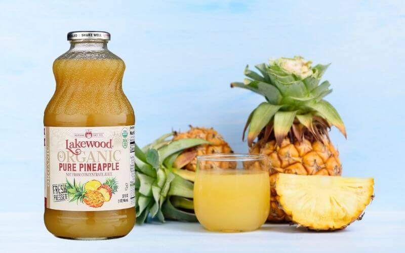 Pineapple juice in a rocks glass with whole pineapples