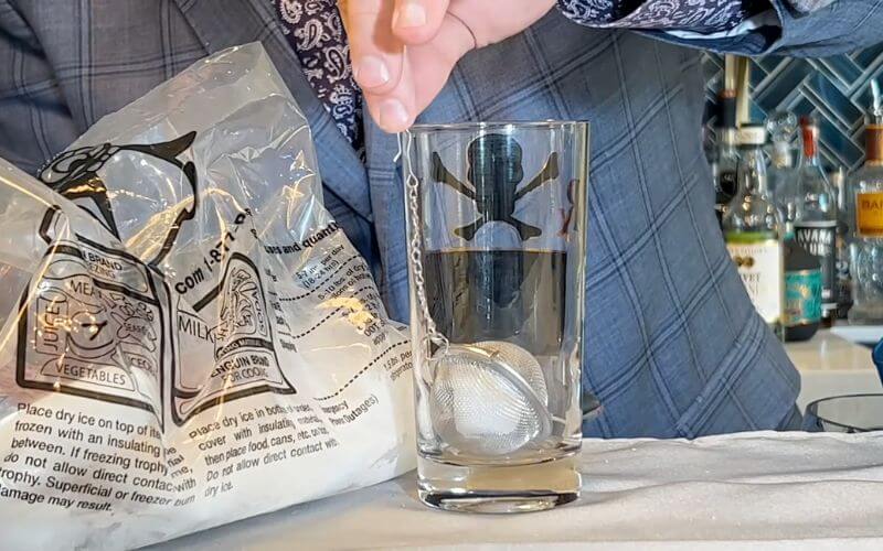 Placing the strainer with dry ice into the glass