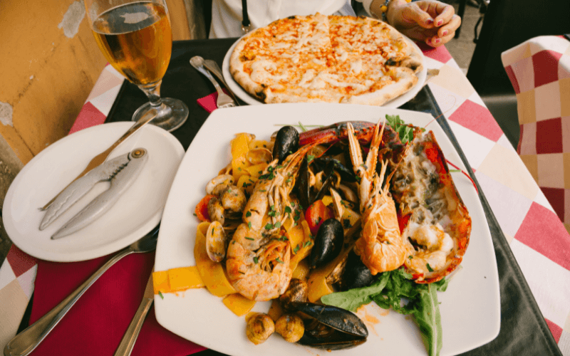 Plate of shrimp, pizza, and a glass of beer