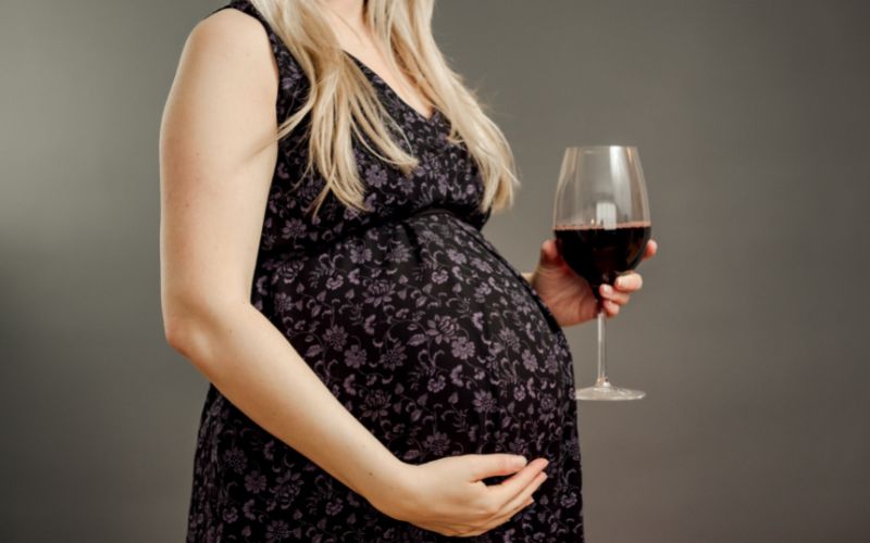 Pregnant woman holding a glass of wine