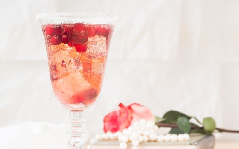 Prosecco Royale with rose and beads background