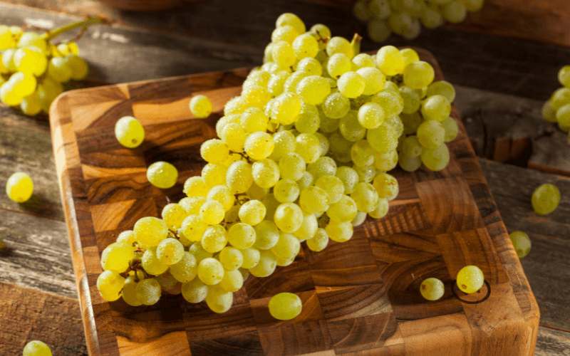 Raw Green Champagne Grapes on a chopping board