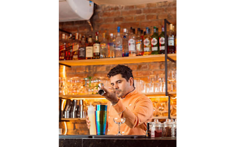 Rick Sousa pouring liquor into a cocktail shaker