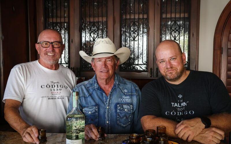 Ron Snyder, George Strait, and Federico Vaughan with a bottle and shot glasses of Codigo