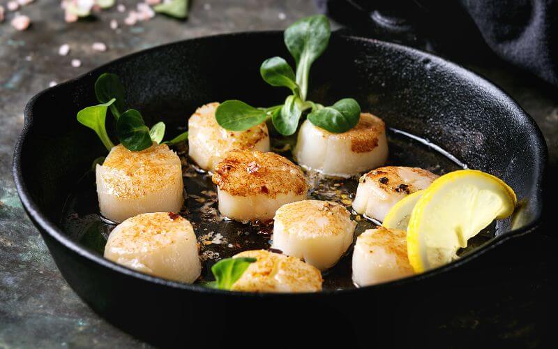 Scallops served with lemon seared in a pan