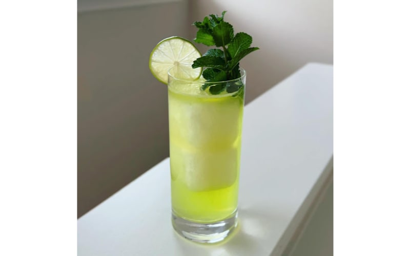 Slam Dunk Da Funk cocktail with a lime wheel and mint garnish