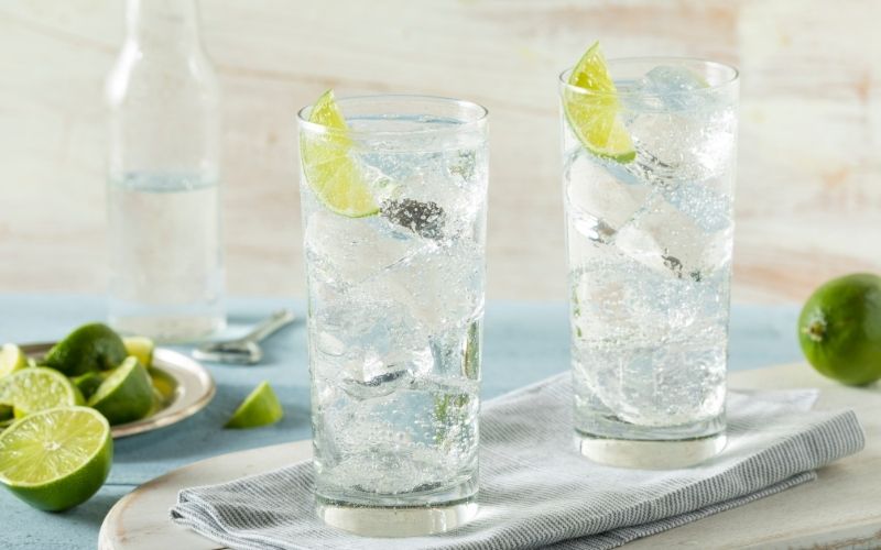 Tall glasses of sparkling water with lime wedges