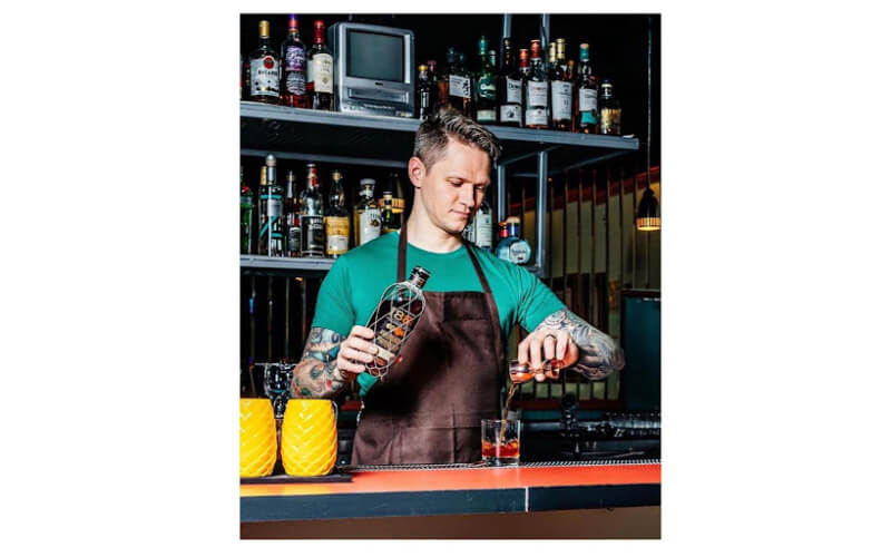 Tom Lasher-Walker pouring liquor into a glass