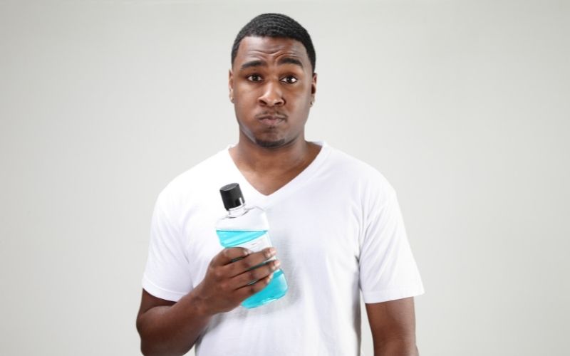 A man holding a bottle of mouthwash