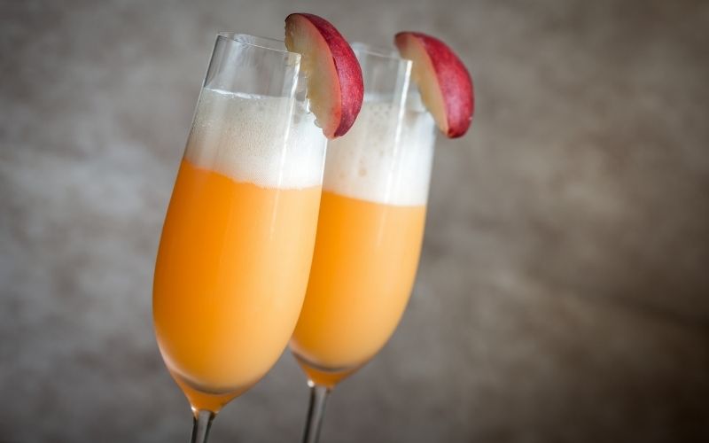 Two Bellini cocktails with peach slices