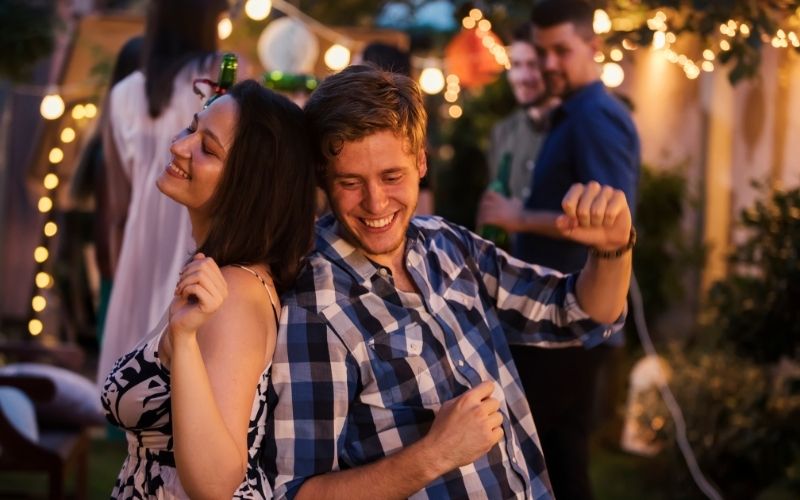 Two friends dancing at a garden cocktail party