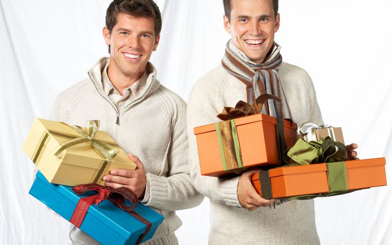 Two men holding wrapped gifts
