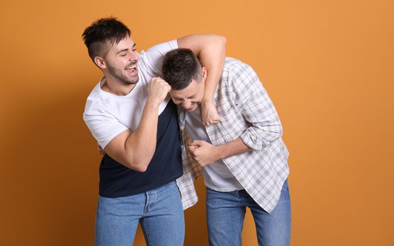 Two men playing around in colored background