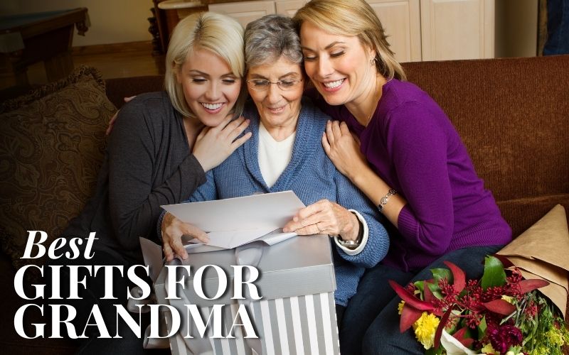 Two women cuddling their grandma with a gift and a letter