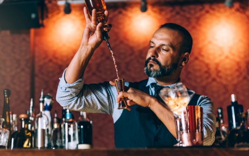 Professional bartender using a liquor pourer