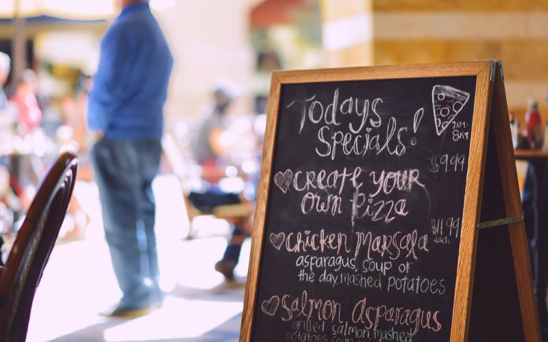 Wooden special menu displayed outdoors 