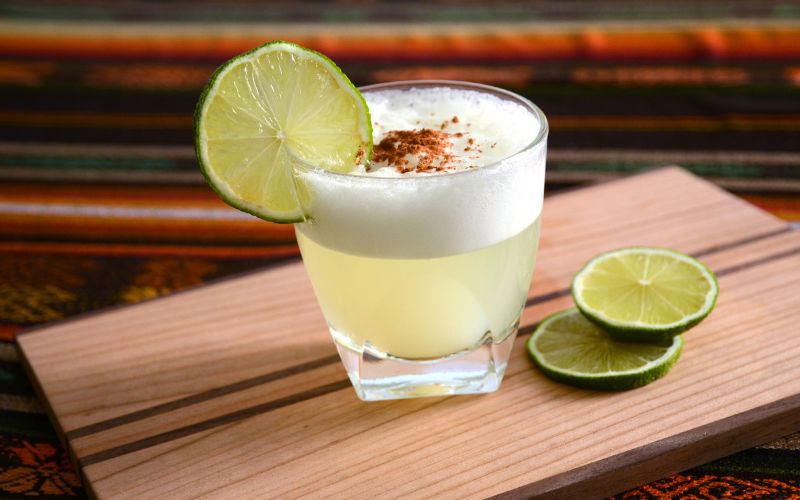 Pisco alcoholic beverage garnished with a lime wedge