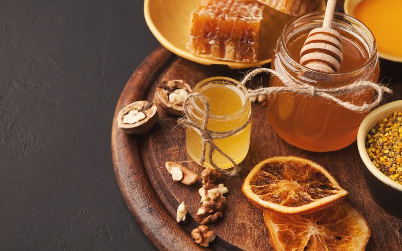 Various types of honey on a wooden platter