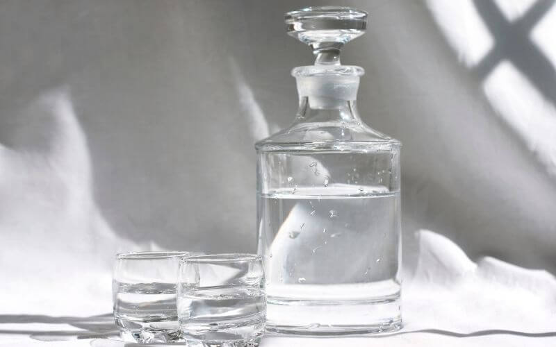 Vodka decanter beside 2 shot glasses with vodka