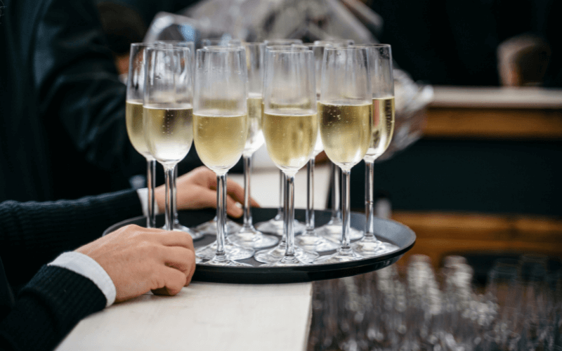 Glasses and bottle of Prosecco on a table with flowers