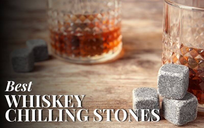 Whiskey stones and glass with liquor on a wooden table